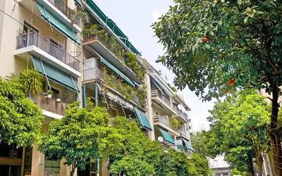 an apartment building with plants on the balconies and trees at Modern Design Acropolis Flat in Athens