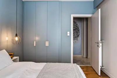 a bedroom with a white bed and a blue wall at Modern Design Acropolis Flat in Athens