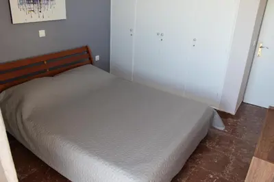 a bed in a small bedroom with a white wall at Apartments MARE BLU by the sea. in Porto Rafti