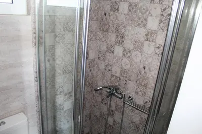 a shower with a glass door and a toilet at Apartments MARE BLU by the sea. in Porto Rafti