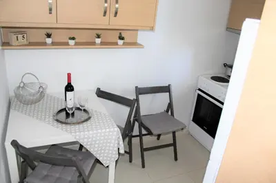 a kitchen with a table with a bottle of wine on it at Apartments MARE BLU by the sea. in Porto Rafti