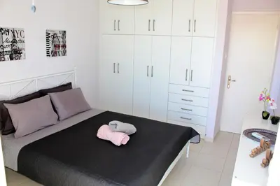 a bedroom with a bed with a stuffed animal on it at Apartments MARE BLU by the sea. in Porto Rafti