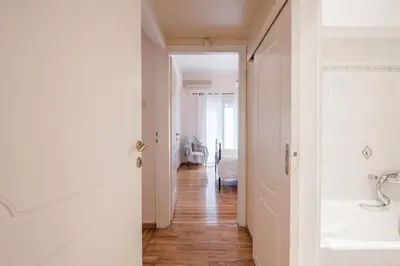 a white bathroom with a sink and a hallway at Retro Apartment at Trendy Exarcheia in Athens