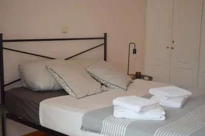 a bed with two folded towels on top of it at Retro Apartment at Trendy Exarcheia in Athens