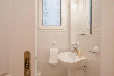 a white bathroom with a sink and a mirror at Retro Apartment at Trendy Exarcheia in Athens