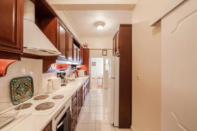a large kitchen with wooden cabinets and a long counter at Retro Apartment at Trendy Exarcheia in Athens