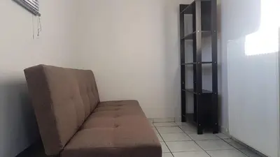 a brown couch in a room with a shelf at Palette Apartment Alice Blue - Athens Center, 3 BD, 2 BATH in Athens