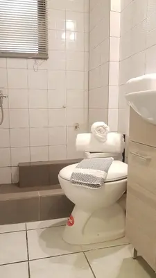 a white bathroom with a toilet and a sink at Palette Apartment Alice Blue - Athens Center, 3 BD, 2 BATH in Athens