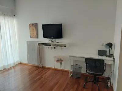 a room with a desk and a television on a wall at Velvendou 36A Apartment in Athens