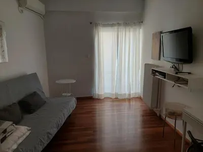a living room with a couch and a flat screen tv at Velvendou 36A Apartment in Athens