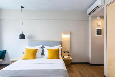 a bedroom with a bed with yellow pillows at St. Bjur Suites in Athens