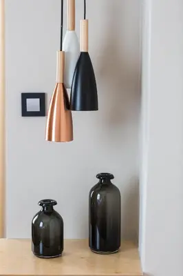 three black vases sitting on a wooden table at St. Bjur Suites in Athens