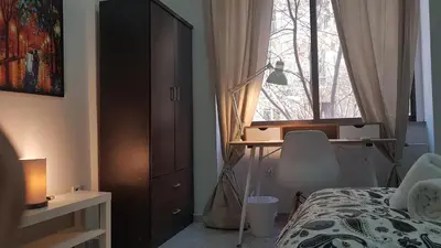 a bedroom with a bed and a desk and a window at Palette Apartment Bamboo - Athens Center, 6 BD, 3 BATH in Athens