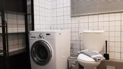 a bathroom with a washing machine and a toilet at Palette Apartment Chocolate - Athens Center, 6 BD, 3 BATH in Athens