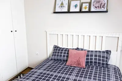 a bed with black and white pillows and a pink pillow at Cozy Studio in the center of Athens in Athens