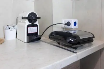 a black iron sitting on a counter next to a toaster at Cozy Studio in the center of Athens in Athens