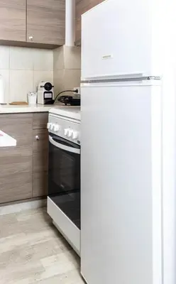 a white refrigerator in a kitchen next to a stove at Cozy Studio in the center of Athens in Athens