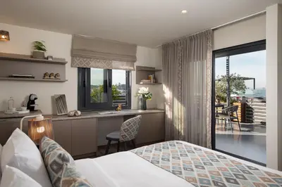 a bedroom with a bed and a kitchen with a balcony at Urban Nest - Suites & Apartments in Athens
