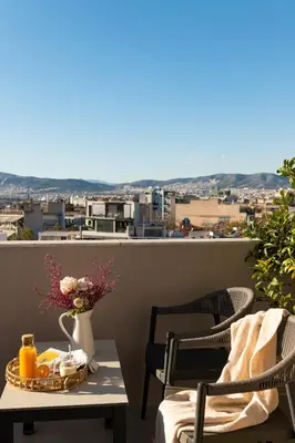a table and chairs on a balcony with a view at Urban Nest - Suites & Apartments in Athens