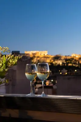 two glasses of white wine sitting on a ledge at Urban Nest - Suites & Apartments in Athens
