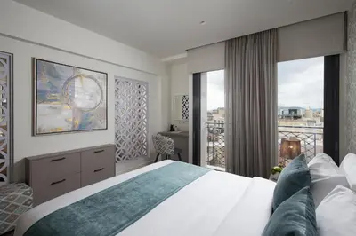a bedroom with a large bed and a balcony at Urban Nest - Suites & Apartments in Athens