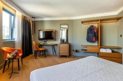 a bedroom with a bed and a desk and a tv at Bob W Athens Eolou in Athens