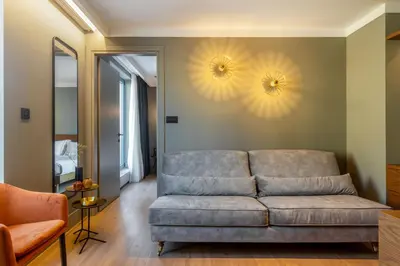 a living room with a couch and two lights on the wall at Bob W Athens Eolou in Athens
