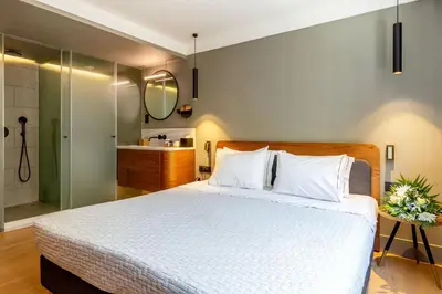 a bedroom with a large bed and a bathroom at Bob W Athens Eolou in Athens