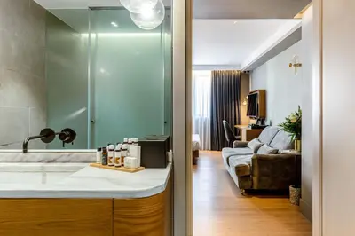 a bathroom with a sink and a living room at Bob W Athens Eolou in Athens
