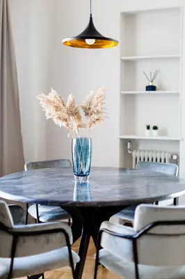 a dining room table with a vase with flowers on it at Elegant Luminous 3BD apartment in Kolonaki by UPSTREET in Athens
