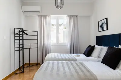 a bedroom with two beds and a window at Elegant Luminous 3BD apartment in Kolonaki by UPSTREET in Athens