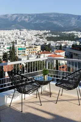a patio with two chairs and a table on a balcony at Elegant Luminous 3BD apartment in Kolonaki by UPSTREET in Athens