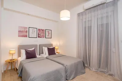 two beds in a white room with a window at Morum Athens Urban Stay in Athens