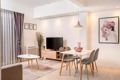 a living room with a table and chairs and a tv at Morum Athens Urban Stay in Athens