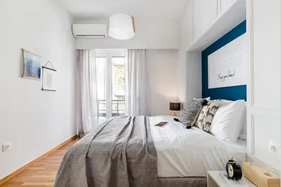 a bedroom with a large bed with a blue accent wall at Desirable 1BD Apartment in Kolonaki by UPSTREET in Athens