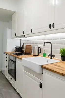 a kitchen with white cabinets and a sink at Desirable 1BD Apartment in Kolonaki by UPSTREET in Athens