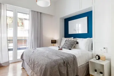 a bedroom with a large bed with a blue wall at Desirable 1BD Apartment in Kolonaki by UPSTREET in Athens