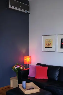 a living room with a black couch with colorful pillows at Homz AH03 Penthouse Studio Hilton Area in Athens