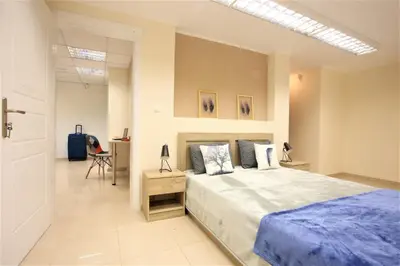 a bedroom with a large bed and a desk at GK Airport Suites - Free Shuttle by GK Properties in Markopoulo