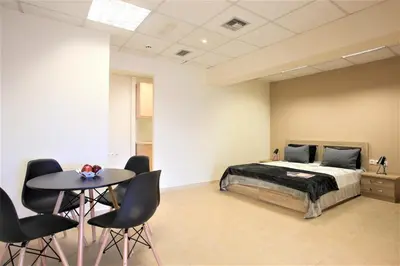 a bedroom with a bed and a table and chairs at GK Airport Suites - Free Shuttle by GK Properties in Markopoulo