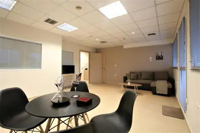 a living room with a table and chairs and a couch at GK Airport Suites - Free Shuttle by GK Properties in Markopoulo