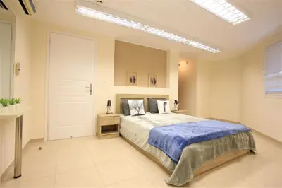 a bedroom with a large bed with a blue blanket at GK Airport Suites - Free Shuttle by GK Properties in Markopoulo