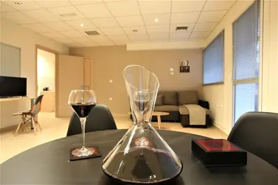a bottle of wine and a glass on a table at GK Airport Suites - Free Shuttle by GK Properties in Markopoulo