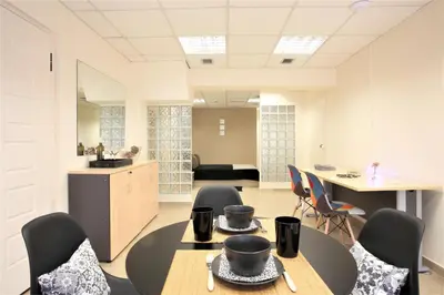 a room with two tables and chairs and a kitchen at GK Airport Suites - Free Shuttle by GK Properties in Markopoulo