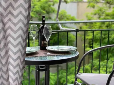 a table with a bottle of wine and glasses on a balcony at Athens Alex Apartment in Athens