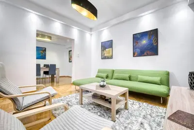 a living room with a green couch and a table at Athens Alex Apartment in Athens
