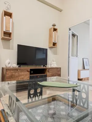 a living room with a glass table and a tv at AS Monastiraki Apartment 1B in Athens