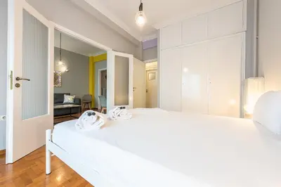 a bedroom with a large white bed with two towels at Athens Boutique Apartment by Cloudkeys in Athens