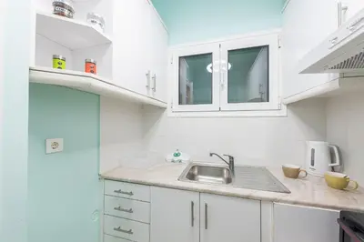 a kitchen with white cabinets and a sink at Athens Boutique Apartment by Cloudkeys in Athens