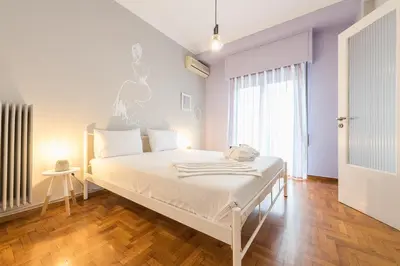 a white bed in a room with a window at Athens Boutique Apartment by Cloudkeys in Athens